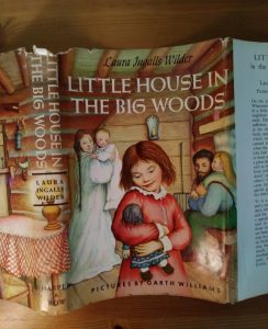 Close up of front of dust jacket of book, Little House in the Big Woods, 1953 Uniform edition