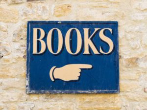 sign with a pointing finger above it says "books"