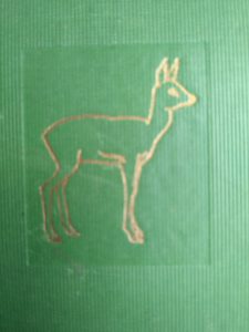 Close up of gold gilt deer on the front cover of a 1928 copy of Bambi A Life in the Woods