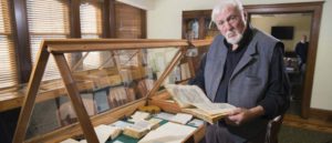 Brian Rex reading a rare book in a collection he started in 1997