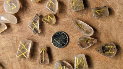 up close picture of a Hand Carved Rune Set on 340 Ct of Natural Golden Rutilated Quartz with a dime for size comparison